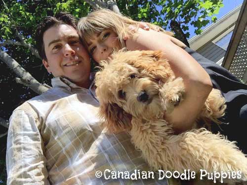 Father and daughter holding Labradoodle puppy